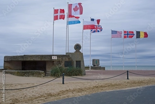 Fototapeta Bernieres-sur-Mer, France - May 1, 2024: Juno Beach D-Day Landing Memorial. Cassine bunker. Queen's Own Rifles of Canada memorial. Cloudy spring day. Selective focus.