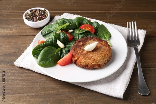 Obraz Tasty vegetarian cutlet served with vegetables on wooden table