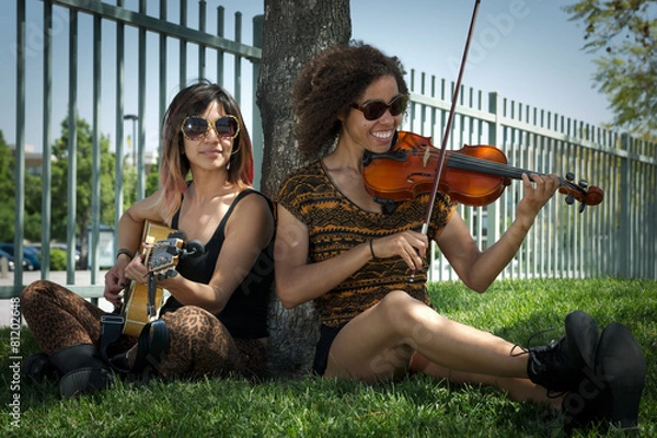 Obraz Female musicians seated under a tree playing instruments