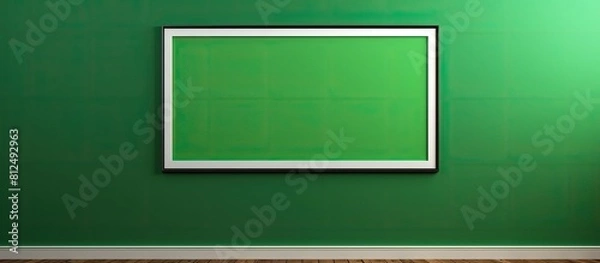 Fototapeta The framed picture on the wall features a green screen to easily incorporate content such as images or text effectively The frame is made of wood and is situated against a black or white wall providi
