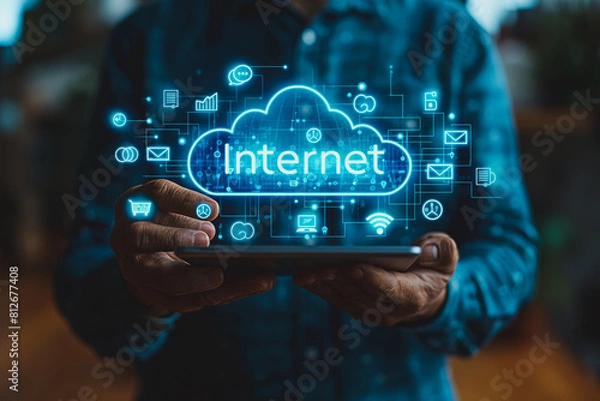 Fototapeta A man is holding a tablet with a blue cloud and the word Internet on it