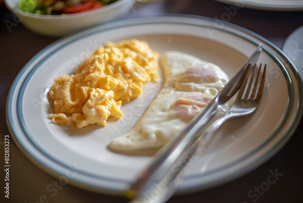 Obraz Scrambled eggs and fried egg on the table for breakfast