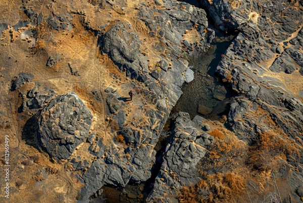 Fototapeta Aerial view of a hunter stealthily navigating through a rugged terrain, blending into the natural environment 