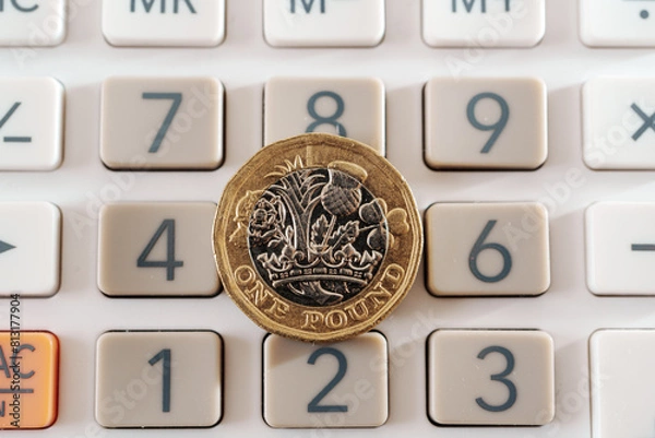 Obraz British one pound coin placed on top of the calculator buttons. Concept for business, planning and finance