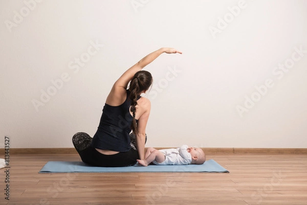 Fototapeta Home exercise for mother and baby, mommy and me workout. Physical activity for mother while bonding with children.