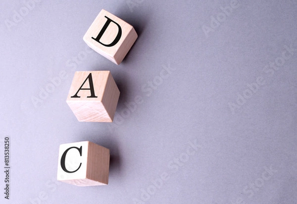 Fototapeta DAC word on wooden block on gray background