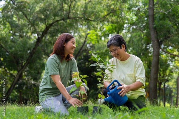 Fototapeta Old Asian Women and daughter join as volunteers for reforestation, earth conservation activities for reduce global warming growth feature and take care nature earth. Environment Concept