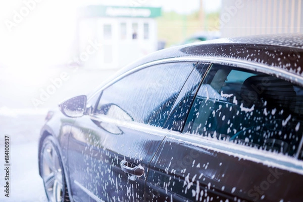 Fototapeta Applying foam for washing the car in bright sunlight