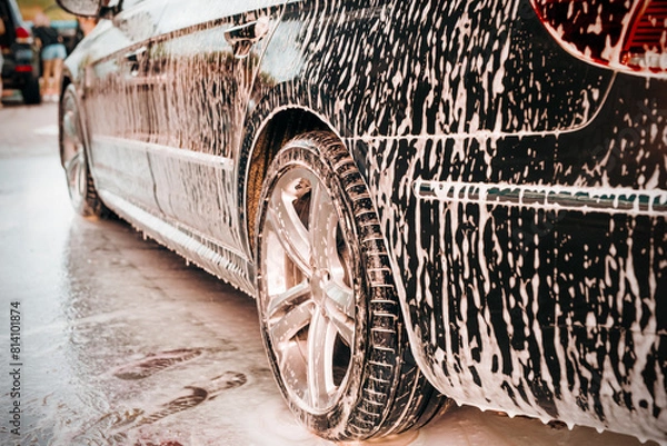 Obraz White foam is applied to the car body at the car wash