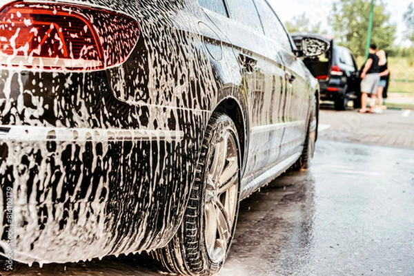 Obraz White foam is applied to the car body at the car wash