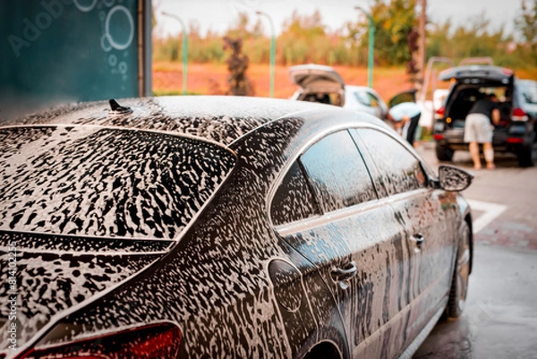 Obraz White foam is applied to the car body at the car wash