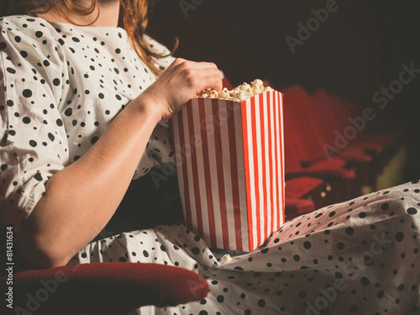 Obraz Młoda kobieta jedzenie popcornu w kinie