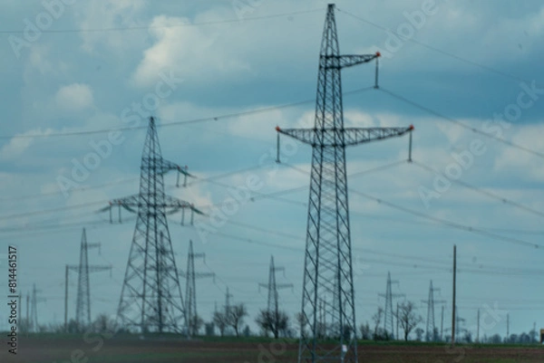 Fototapeta High voltage towers with sky background. Power line support with wires for electricity transmission. High voltage grid tower with wire cable at distribution station. Energy industry, energy saving