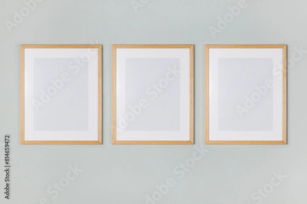 Fototapeta Three empty picture frames hanging on the wall