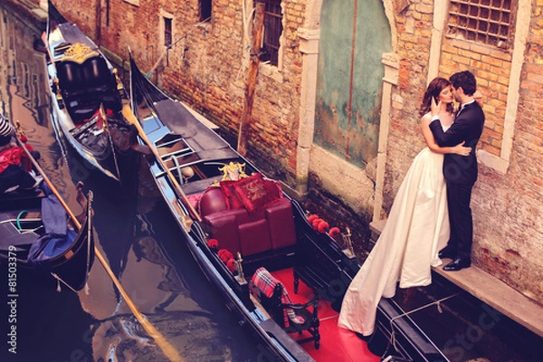 Fototapeta Bride and groom embracing in Venice