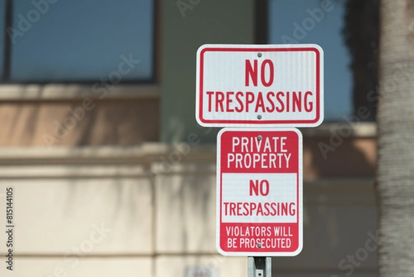 Obraz Rectangle image of a red and white no trespassing sign screwed to a metal post.