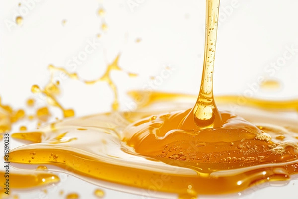 Fototapeta Raw honey drips, thick and golden, isolated on white with a glossy shine.