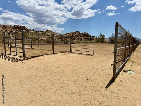 Fototapeta A rustic scene of a Wild West desert corral, surrounded by arid landscapes and rugged terrain, evoking the spirit of frontier life and cowboy heritage.
