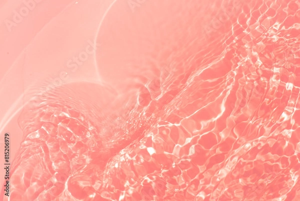 Fototapeta Red water bubbles on the surface ripples. Defocus blurred transparent pink colored clear calm water surface texture with splash and bubbles. Water waves with shining pattern texture background
