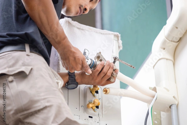 Fototapeta Technician installed new air conditioner, Man cut joints with the tool of copper pipe to fix and install new air conditioner
