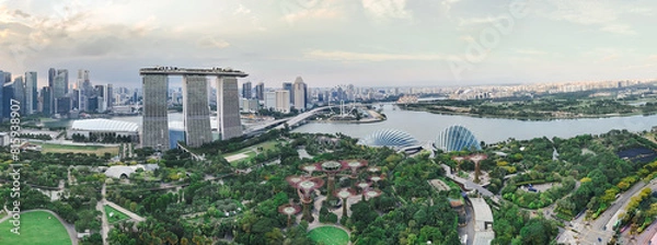 Fototapeta Marina Bay in Singapore features the iconic Marina Bay Sands, Gardens by the Bay, Helix Bridge, and the Singapore Flyer. It offers stunning views of modern architecture, lush greenery, and the vibrant