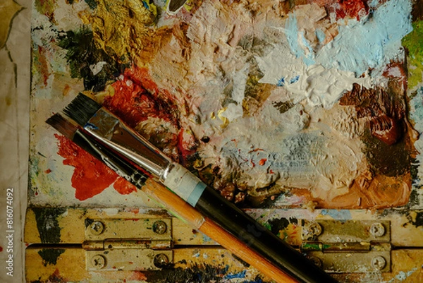 Fototapeta Used brushes on an artist's palette of colorful oil paint