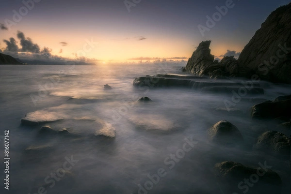 Fototapeta Sunset on Azkorri or Gorrondatxe beach, in Getxo, Bizkaia, with the waves passing over the rocks
