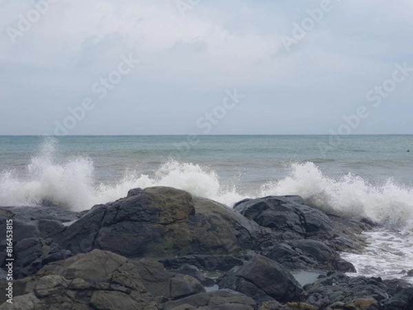 Fototapeta Image of a wave crashing on the rock