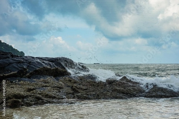 Fototapeta Image of a wave crashing on the rock