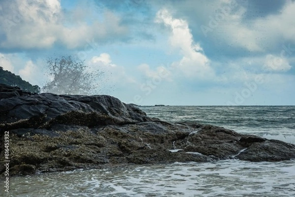Fototapeta Image of a wave crashing on the rock