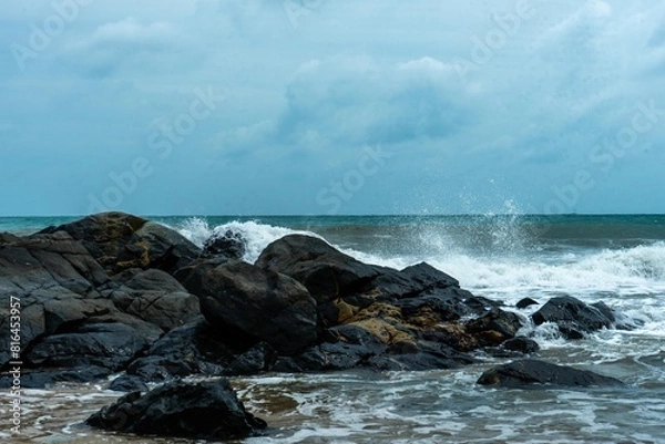 Fototapeta Image of a wave crashing on the rock