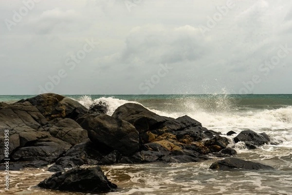Fototapeta Image of a wave crashing on the rock