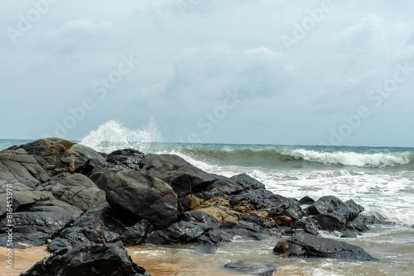 Fototapeta Image of a wave crashing on the rock