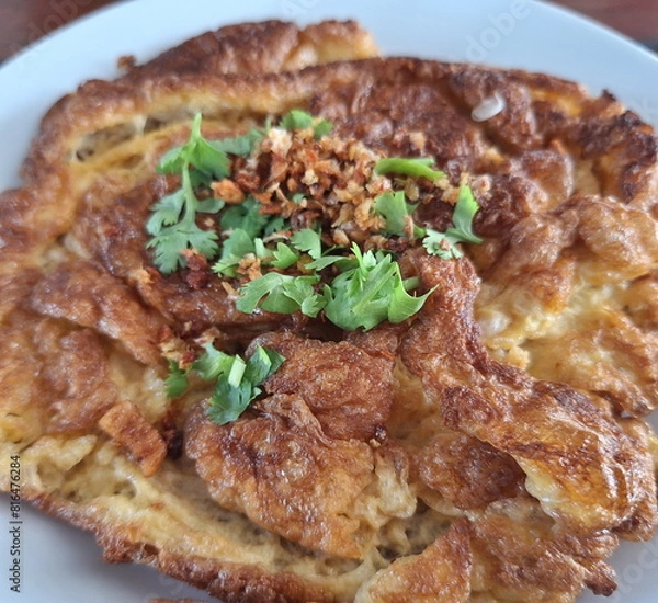 Fototapeta Freshly prepared Asian deep-fried crispy egg omelet.