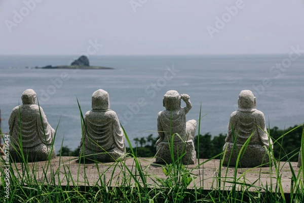Obraz Buddha statues with view to Yongmeori coast at Sanbanggulsa temple in summer, Jeju Island, South Korea