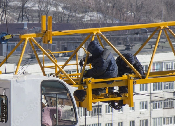 Fototapeta Two mechanics repairing a crane