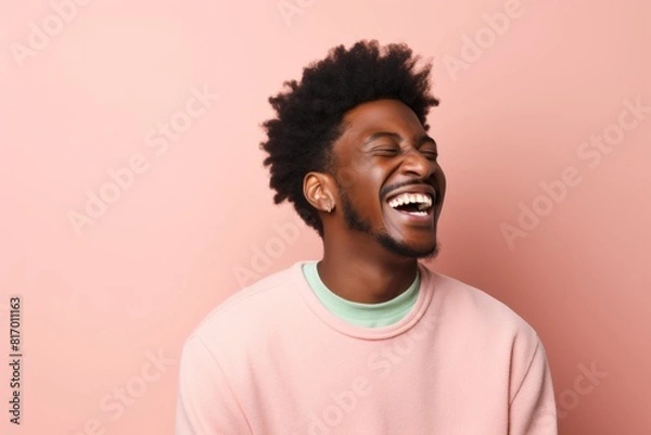 Fototapeta Portrait of a content afro-american man in his 20s laughing isolated on pastel or soft colors background