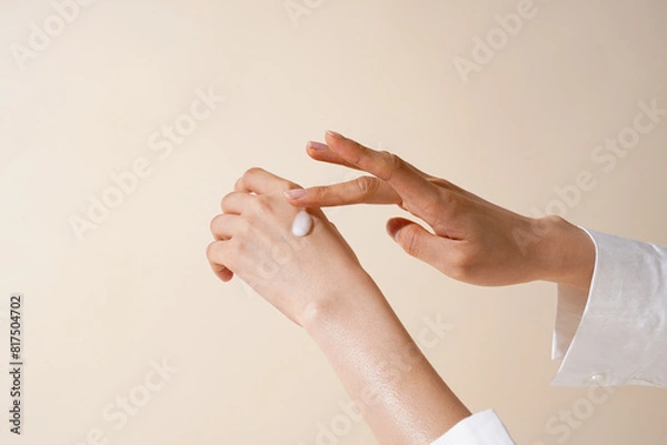 Fototapeta ベージュ色の背景で撮影をしたアジア女性の肌と美容クリームのテクスチャ