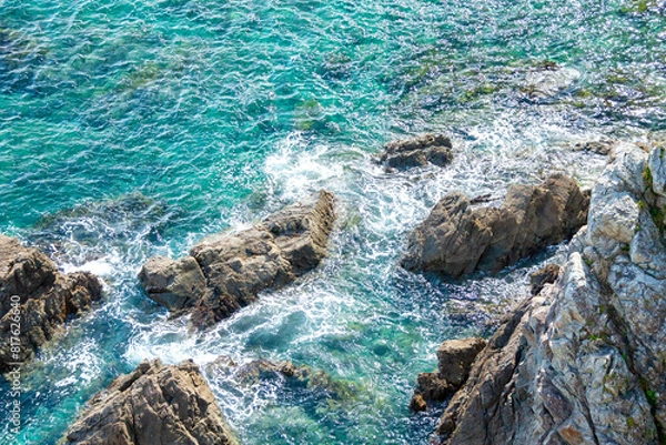 Fototapeta 透明度の高い海の岩礁に打ち寄せる波
