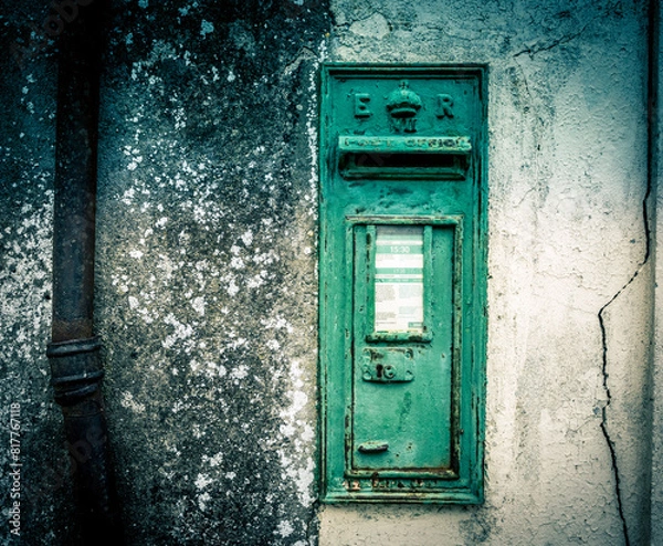 Fototapeta a mail box on the side of a stone wall with a rusted metal handle