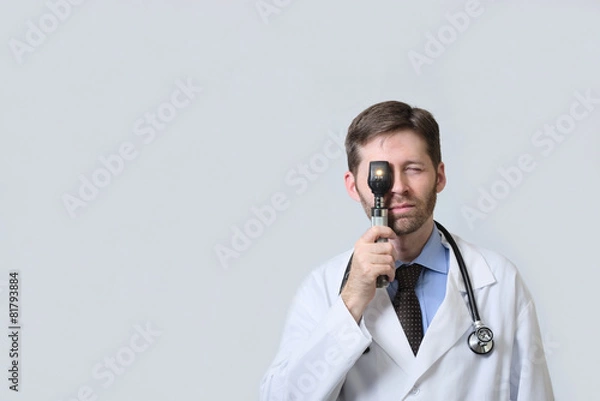 Obraz Physician looking through ophthalmoscope