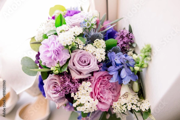 Obraz A gorgeous assortment of purple and pink flowers in an arrangement by a windowsill. 