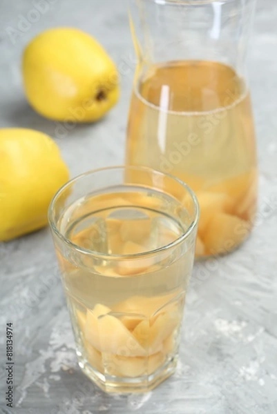 Fototapeta Delicious quince drink and fresh fruits on grey table, closeup
