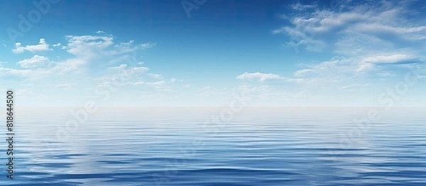 Fototapeta A serene scene with a clear blue sky mirrored in a calm blue ocean creating a captivating copy space image