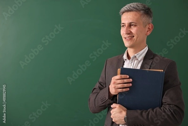 Fototapeta Teacher with notebooks near chalkboard, space for text