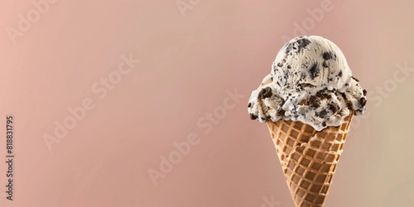 Fototapeta cookies and cream ice cream with waffle cone isolated on a beige background, copy space