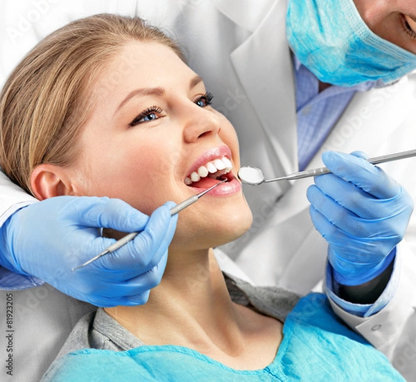 Fototapeta Zdrowie stomatologiczne. Mężczyzna dentysta leczy pacjentkę