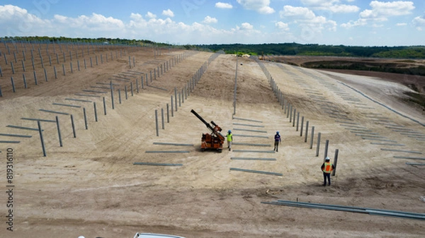 Fototapeta Piling machine in solar farm construction during 2024, shot from drone
