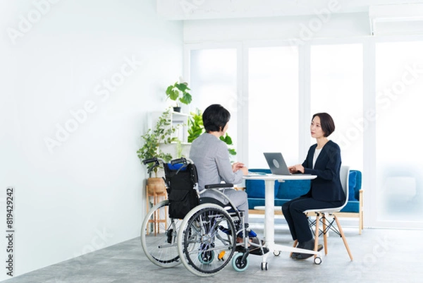 Fototapeta 車椅子に乗って働くビジネスウーマン