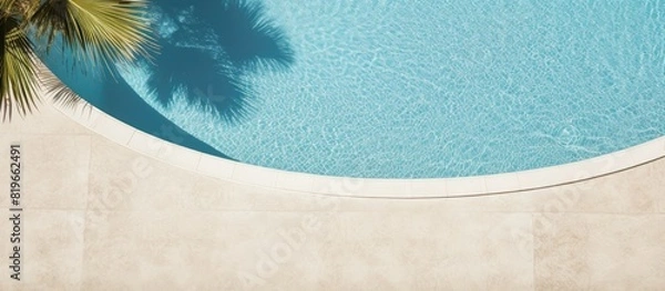 Fototapeta Top down view of a swimming pool background with a water ring and palm shadow visible on the travertine stone perfect for copy space images